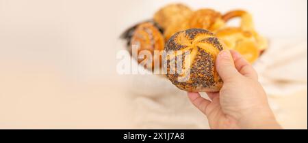 In rus werden verschiedene rötliche Gebäckstücke, Brotprodukte, Bäckerei, Brötchen, Käse- und Mohnbrötchen, Brezeln und Hüttenkäsekuchen präsentiert Stockfoto