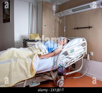 Frau liegt in einem Krankenhausbett mit einer drain.Netherlands vvbvanbree Fotografie Stockfoto