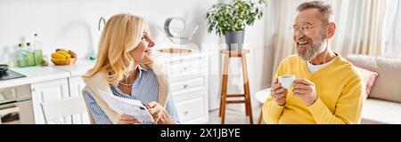 Ein reifes, liebevolles Paar, das in einem gemütlichen Wohnzimmer steht und einen Moment der Intimität und Verbindung teilt. Stockfoto