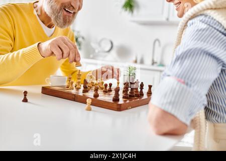 Ein Mann und eine Frau, die in einer strategischen Schlacht des Schachs verwickelt sind und über ihre nächsten Züge in einem gemütlichen Zuhause nachdenken. Stockfoto