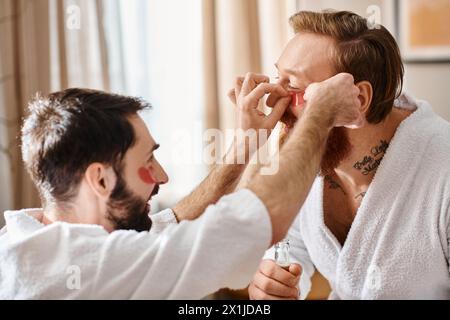 Zwei Männer in Bademänteln helfen sich fröhlich, Augenflecken zu machen. Stockfoto