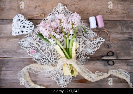 Frühlingsstrauß aus weißen und lila Hyazinthen, Serviette, Schere, Spitze auf altem Holztisch, Frühlingseinrichtung, Weihnachtsgrüße, Neuanfang Stockfoto