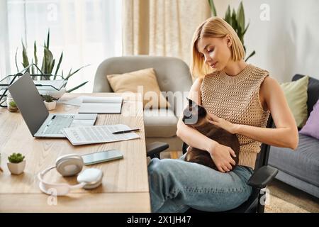 Eine Frau mit kurzen Haaren sitzt friedlich auf einem Stuhl, hält und verbindet sich mit ihrer geliebten Katze zu Hause. Stockfoto