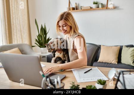 Eine Frau mit kurzen Haaren sitzt friedlich an einem Tisch mit einer Katze auf dem Schoß. Stockfoto