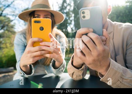 Mann und Frau, die auf ein Handy schauen. Technologiesüchtige Stockfoto