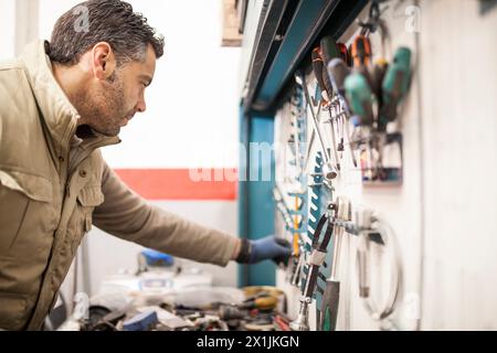 Mechaniker nimmt einen Werkzeugkastenschlüssel in der Mechanikerwerkstatt ab Stockfoto