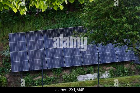 Solarenergie-Panels am Hang neben dem Haus Stockfoto