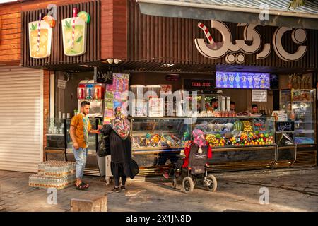 Iranische Frauen kaufen frisch gepressten Fruchtsaft und Eis bei einem Straßenverkäufer im New Julfa, Armenian Quarter in Isfahan, Iran. Stockfoto