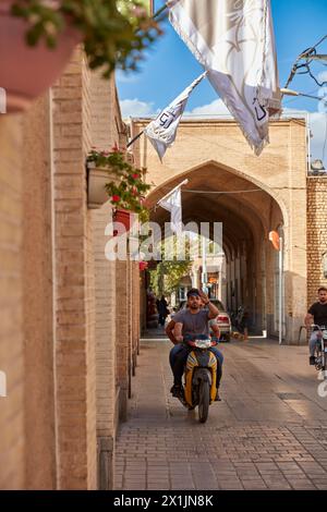 Ein Mann fährt Motorrad in einer schmalen Straße in New Julfa, armenischer Nachbarschaft von Isfahan, Iran. Stockfoto