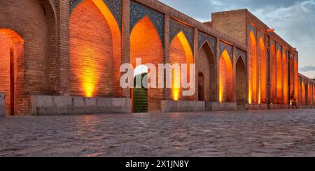 Panoramablick auf die beleuchteten Gewölbebögen der Khaju-Brücke aus dem 17. Jahrhundert auf dem Fluss Zayanderud in der Abenddämmerung. Isfahan, Iran. Stockfoto