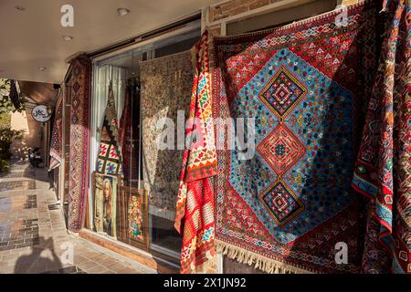 Farbenfrohe persische Teppiche werden vor einem lokalen Teppichgeschäft im Armenischen Viertel Isfahan, New Julfa, Iran, ausgestellt. Stockfoto