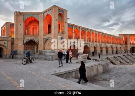 Während der Trockenzeit laufen die Menschen an der beleuchteten Khaju-Brücke aus dem 17. Jahrhundert auf dem Fluss Zayanderud mit trockenem Flussbett. Isfahan, Iran. Stockfoto