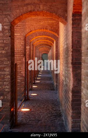 Ein Blick durch beleuchtete Gewölbebögen auf die Khaju-Brücke aus dem 17. Jahrhundert auf dem Fluss Zayanderud in Isfahan, Iran. Stockfoto