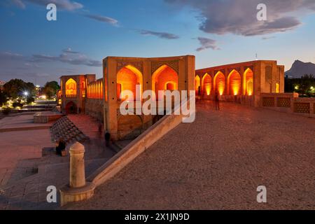 Blick auf die beleuchtete Khaju-Brücke aus dem 17. Jahrhundert auf dem Fluss Zayanderud während der Trockenzeit mit trockenem Flussbett. Isfahan, Iran. Stockfoto