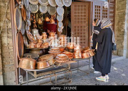 Zwei iranische Frauen kaufen Kochgeschirr aus Kupfer in einem kleinen Geschäft am Naqsh-e Jahan Platz, dem UNESCO-Weltkulturerbe. Isfahan, Iran. Stockfoto