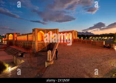 Blick auf die beleuchtete Khaju-Brücke aus dem 17. Jahrhundert auf dem Fluss Zayanderud während der Trockenzeit mit trockenem Flussbett. Isfahan, Iran. Stockfoto