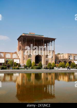 Blick auf den Ali Qapu Palast spiegelt sich in einem Wasserpool auf dem Naqsh-e Jahan Platz, dem UNESCO-Weltkulturerbe. Isfahan, Iran. Stockfoto