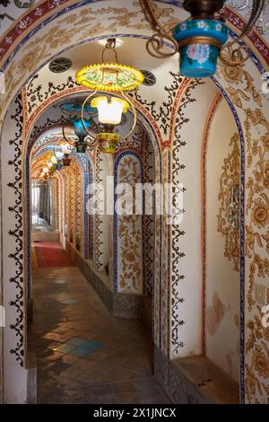 Reich verzierter Flur mit Bogendecke und farbenfrohen Lampen im Retro-Stil im Mollabashi Historical House. Isfahan, Iran. Stockfoto