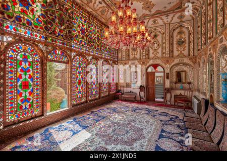 Verziertes Inneres der Empfangshalle (Shahneshin) mit großen bunten Buntglasfenstern im Mollabashi Historical House in Isfahan, Iran. Stockfoto