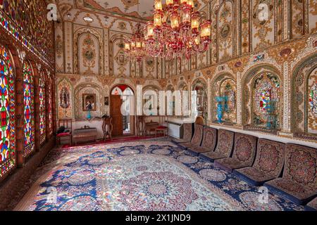 Verziertes Inneres der Empfangshalle (Shahneshin) mit großen bunten Buntglasfenstern im Mollabashi Historical House in Isfahan, Iran. Stockfoto