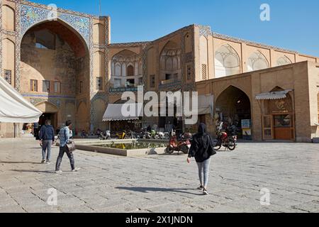 Die Leute laufen am Qeysarie-Tor, dem Haupttor zum Großen Basar von Isfahan auf dem Naqsh-e Jahan-Platz. Isfahan, Iran. Stockfoto