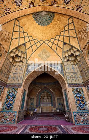 Blick von innen auf die Hakim-Moschee mit kunstvollen Fliesenmosaiken an den Ziegelwänden und der gewölbten Decke. Isfahan, Iran. Stockfoto