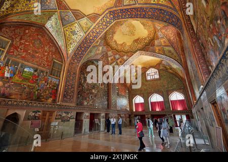 Touristen sehen das kunstvolle Innere des Chehel Sotoun Palace aus dem 17. Jahrhundert in Isfahan, Iran. Stockfoto