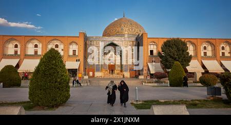 Iranische Frauen in schwarzen Chadors gehen an der Lotfollah-Moschee auf dem Naqsh-e Jahan-Platz. Isfahan, Iran. Stockfoto