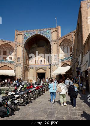 Die Leute laufen am Qeysarie-Tor, dem Haupttor zum Großen Basar von Isfahan auf dem Naqsh-e Jahan-Platz. Isfahan, Iran. Stockfoto