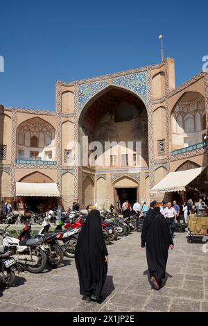 Die Leute laufen am Qeysarie-Tor, dem Haupttor zum Großen Basar von Isfahan auf dem Naqsh-e Jahan-Platz. Isfahan, Iran. Stockfoto