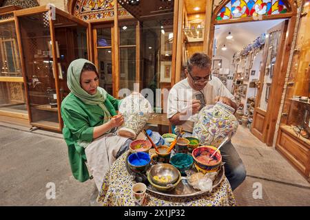 Iranische Handwerker malen große Keramiktöpfe vor der endgültigen Verglasung von Hand. Großer Basar, Isfahan, Iran. Stockfoto