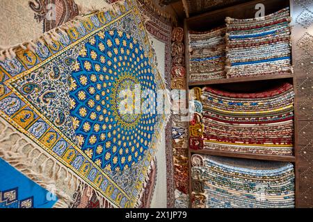 Eine Auswahl an Tischdecken aus Ghalamkar (traditionelle iranische Textildruckkunst), ausgestellt in einem Kunsthandwerksgeschäft auf dem Großen Basar von Isfahan, Iran. Stockfoto