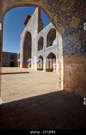 Blick auf den Innenhof der Shah Moschee (Masjed-e Shah) durch einen Bogen mit aufwendigen Fliesen. Isfahan, Iran. Stockfoto