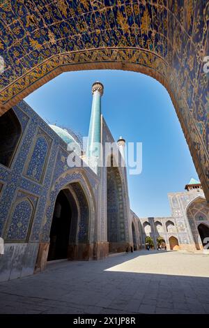 Blick auf den Innenhof auf die Shah Moschee (Masjed-e Shah) durch einen Bogen mit aufwendiger gekachelter Decke. Isfahan, Iran. Stockfoto