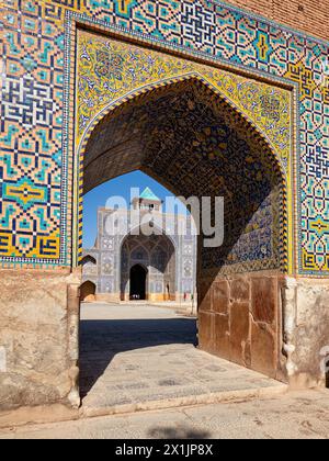 Blick auf den Innenhof der Shah Moschee (Masjed-e Shah) durch einen Bogen mit aufwendigen Fliesen. Isfahan, Iran. Stockfoto