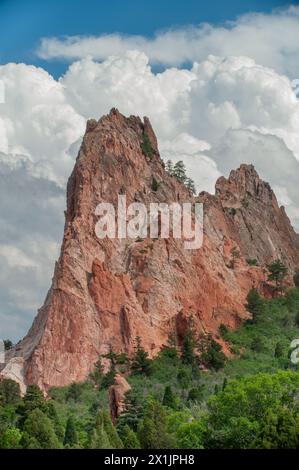 Unter einem riesigen blauen Himmel erhebt sich eine hoch aufragende rote Felsformation, die das zerklüftete Herzland Colorados und die Pracht der bergigen Natur repräsentiert Stockfoto