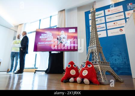 Berlin, Deutschland. April 2024. Zwei phrygische Mützen, die Maskottchen der Olympischen Spiele 2024 in Paris, liegen vor einer Figur des Eiffelturms. 100 Tage vor Beginn der Olympischen Spiele 2024 hält das Team Berlin eine Pressekonferenz in der französischen Botschaft in Berlin ab. Quelle: Hannes P. Albert/dpa/Alamy Live News Stockfoto