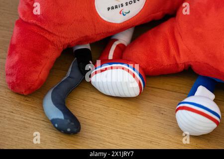 Berlin, Deutschland. April 2024. Zwei Phrygianische Mützen, die Maskottchen der Olympischen Spiele 2024 in Paris, liegen vor einer Figur des Eiffelturms. Eines der Maskottchen hat eine Beinprothese. 100 Tage vor Beginn der Olympischen Spiele 2024 hält das Team Berlin eine Pressekonferenz in der französischen Botschaft in Berlin ab. Quelle: Hannes P. Albert/dpa/Alamy Live News Stockfoto