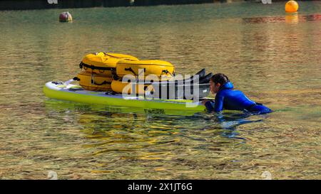 Ein Freitaucher schwimmt mit einem Paddleboard auf dem Weg zum Tauchplatz. Stockfoto