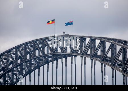 Nahaufnahme der Sydney Harbour Bridge, Brückenkletterer standen auf dem Gipfel unter der australischen Nationalflagge und der Flagge der Aborigines, Sydney, 2024 Stockfoto