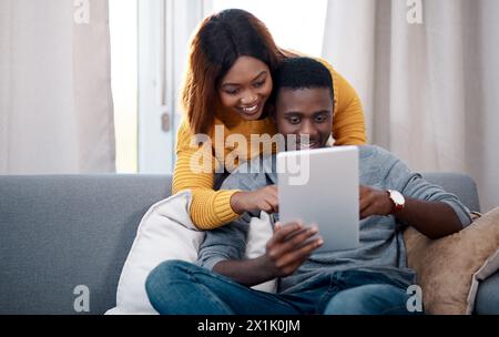 Liebes-, Tablet- und schwarzes Paar umarmen sich auf dem Sofa mit sozialen Medien, Streaming oder Anmeldung zu Hause. Digital, Suche und App für Online-Shopping Stockfoto