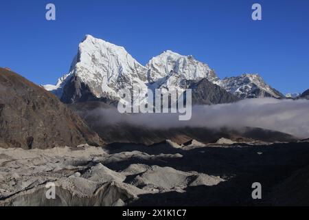 Unterer Teil des Ngozumba-Gletschers und schneebedeckte Berge Cholatse und Tobuche, Nepal. Stockfoto