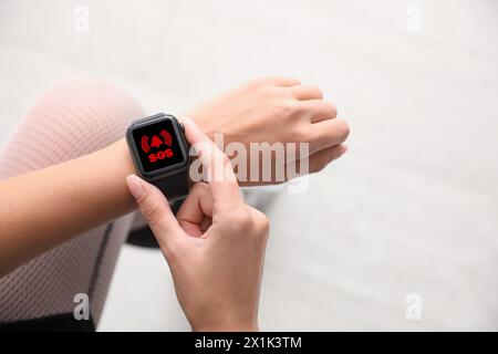 Frau mit SOS-Funktion bei Smartwatch im Freien, Nahaufnahme Stockfoto