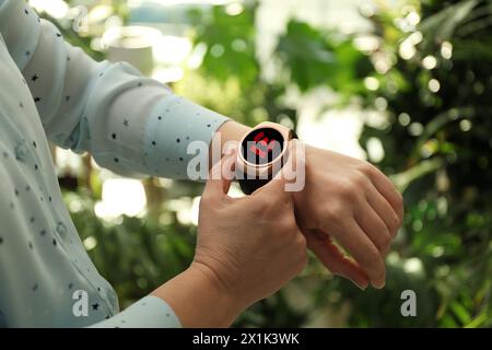 Frau mit SOS-Funktion bei Smartwatch im Freien, Nahaufnahme Stockfoto