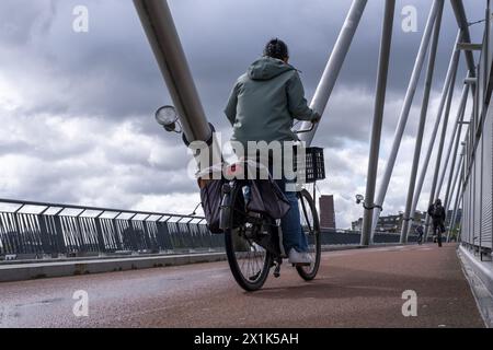 Niederlande, Nijmegen, 16-04-2024, - Fußgänger und Radfahrer müssen mit Wind und Regen auf der Brücke zu kämpfen haben. Es gibt Pfützen und starke Windböen. Foto: ANP/Hollandse Hoogte/ Manon Bruininga netherlands Out - belgien Out Stockfoto