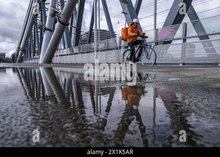 Niederlande, Nijmegen, 16-04-2024, - Fußgänger und Radfahrer müssen mit Wind und Regen auf der Brücke zu kämpfen haben. Es gibt Pfützen und starke Windböen. Foto: ANP/Hollandse Hoogte/ Manon Bruininga netherlands Out - belgien Out Stockfoto