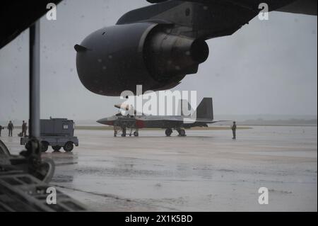 Sicherheitskräfte der US Air Force und Wartungsflugzeuge, die dem 3. Air Expeditionary Wing zugeordnet sind, erhalten und bereiten einen F-22 Raptor vor Stockfoto