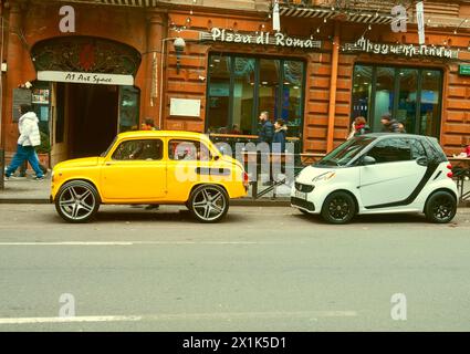 Jerewan, Armenien - 12. Dezember 2022: Treffen von Alt und Neu. Sowjetischer Wagen der 60er Jahre Zaporoschets und moderner Elektroauto Mercedes stehen nebeneinander Stockfoto