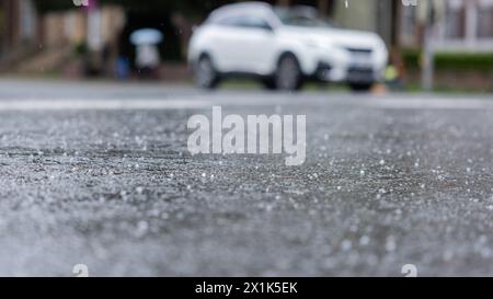 17. April 2024, Nordrhein-Westfalen, Münster: Hagel ist bei einer Dusche auf einer Straße zu sehen. Foto: Rolf Vennenbernd/dpa Stockfoto