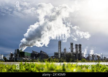 ROTTERDAM – Außenansicht der Raffinerien im Hafen von Rotterdam, die CO2 bei dunklem Himmel von einem Regenschauer im Hintergrund ausstoßen. niederlande aus - belgien aus Stockfoto